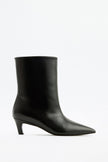 Mescini black pointed toe ankle boots, full side view on a studio backdrop, US sizes