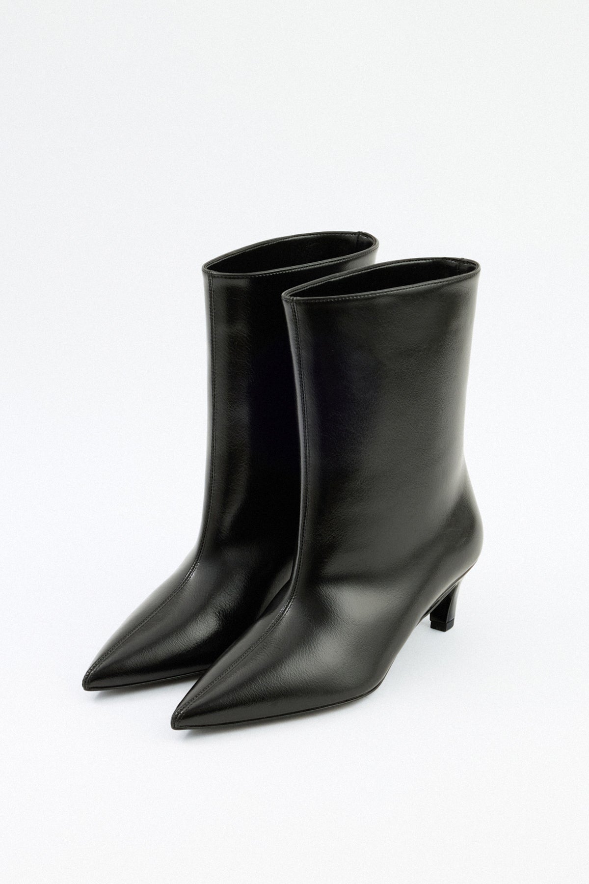 Mescini black pointed toe ankle boots, angled pair view on a pale floor, US sizes
