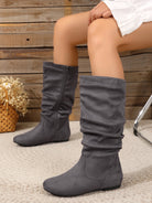 Mescini gray pleated slouch flat mid calf boots, worn by a seated model, angled view, US women's sizes