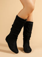 Mescini black pleated slouch flat mid calf boots, side view of the pair on a model, US women's sizes