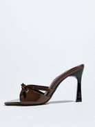 Mescini brown bow pointed toe stiletto mules, one shoe seen from the side, US women's sizes