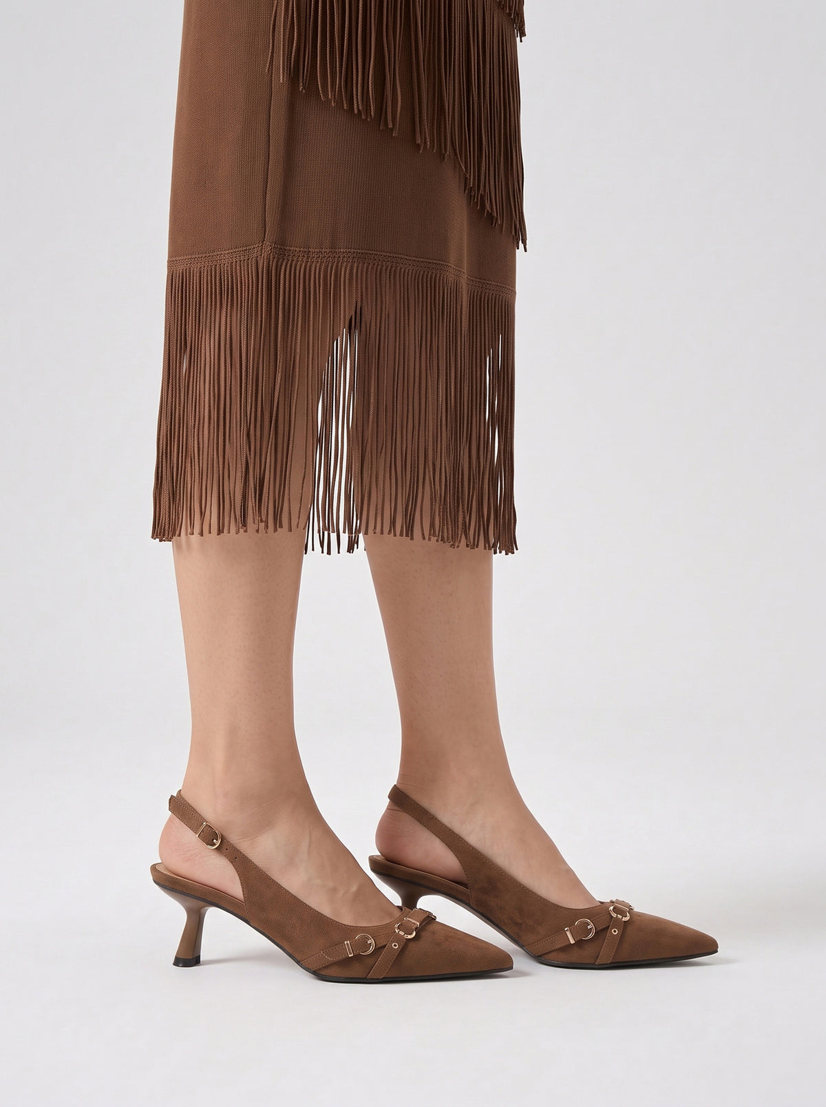 Mescini brown buckle strap pointed slingback heels, worn standing, seen from behind, US women's sizes