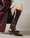 Mescini burgundy kitten heel knee high boots, worn by a model in a matching coat, US women's sizes