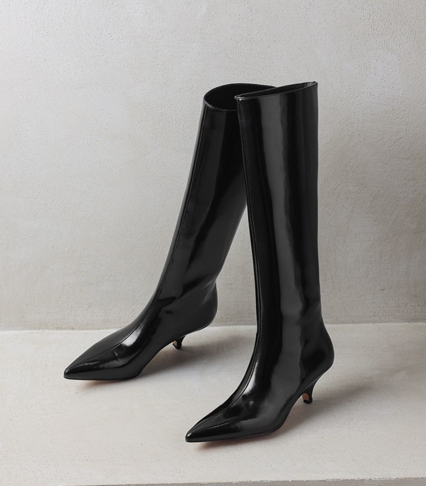 Mescini black kitten heel knee high boots, the pair standing on a pale set, US women's sizes