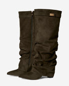 Mescini olive green slouchy knee high boots, worn by a model seated on a bench, US sizes