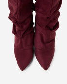 Mescini burgundy slouchy knee high boots, worn by a model seated on a bench, US sizes