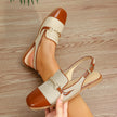 Mescini brown cap toe slingback flat sandals, held in a hand, sling strap in view, US women's sizes