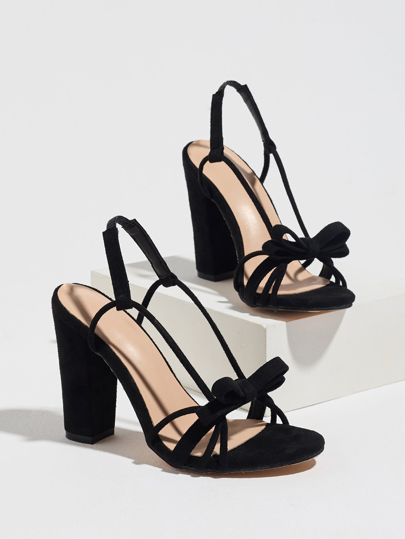 Mescini black knotted bow strappy block heel sandals, angled pair view on grey, US women's sizes