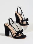 Mescini black knotted bow strappy block heel sandals, angled pair view on grey, US women's sizes