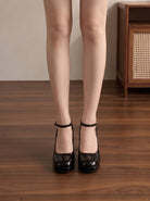 Mescini black ankle strap platform block heel pumps, worn standing, seen from the front, US women's sizes