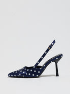 Mescini navy polka dot slingback stiletto heels, single shoe photographed from the side, US women's sizes