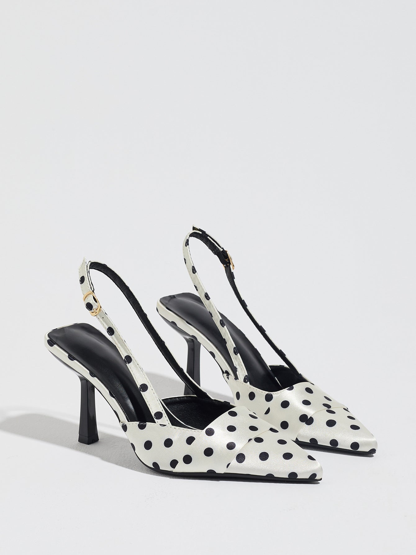 Mescini white polka dot slingback stiletto heels, pair angled on a light grey floor, US women's sizes
