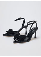Mescini – Black bow pointed toe ankle strap pumps, angled studio pair, US women's sizes