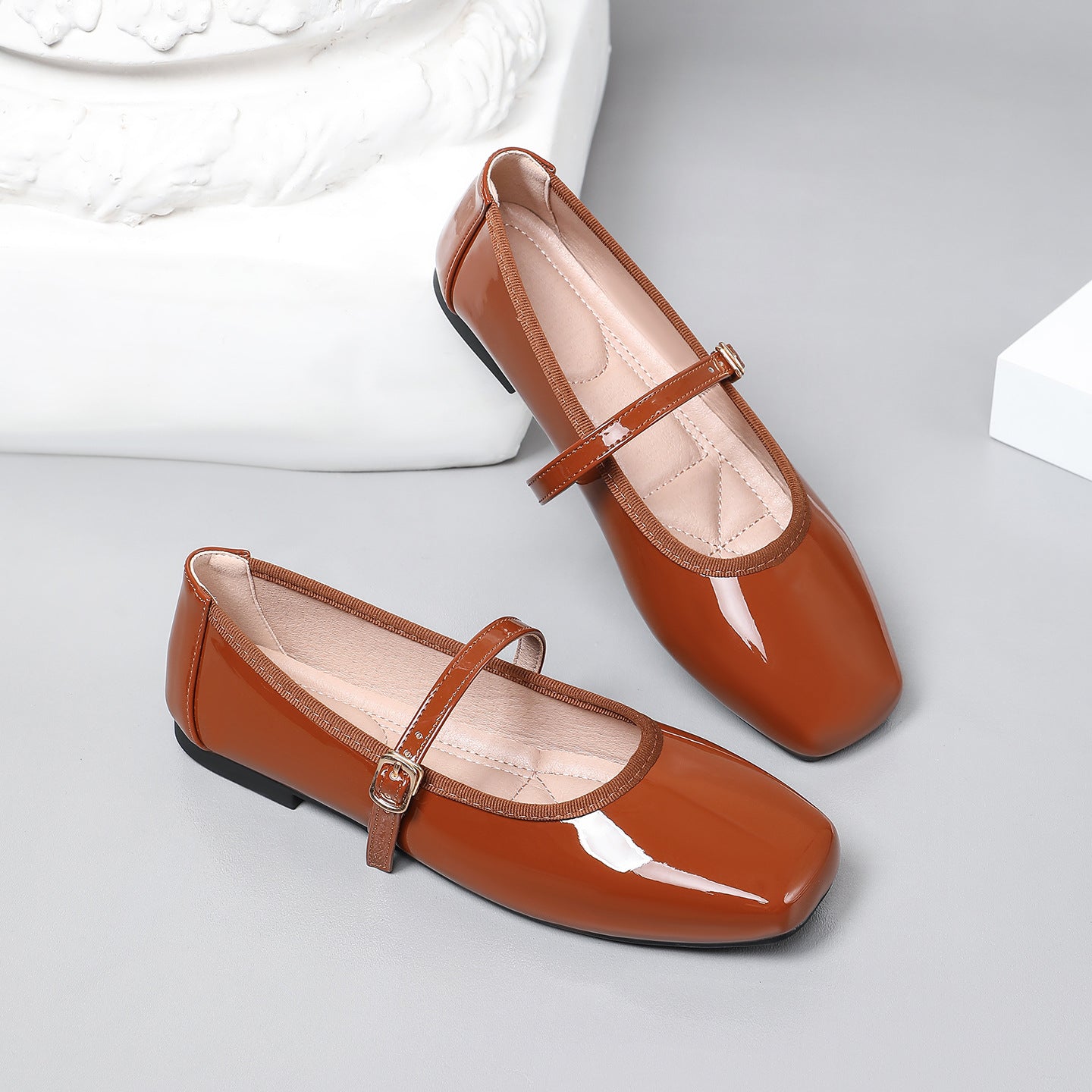 Mescini brown patent square toe mary jane flats, pair leaning against a white block, US women's sizes