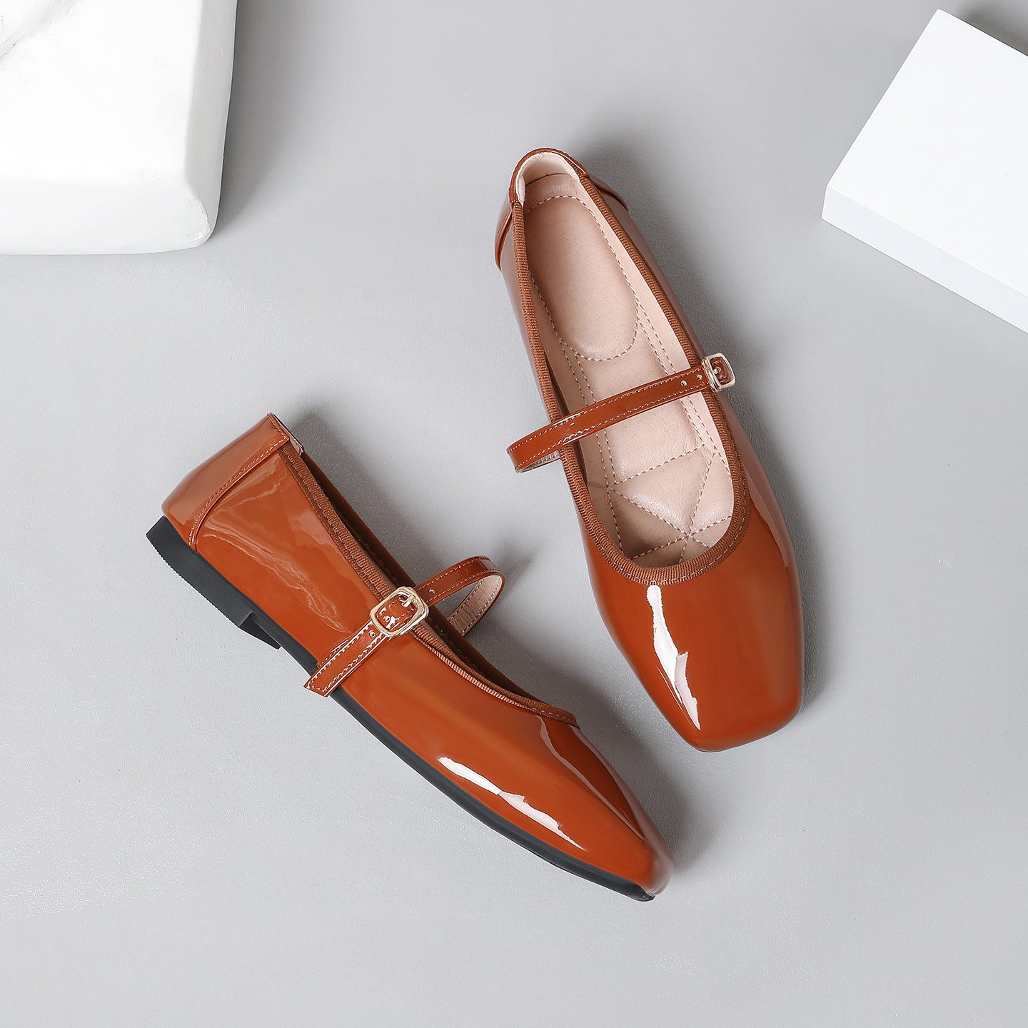 Mescini brown patent square toe mary jane flats, pair with one shoe turned on its side, US women's sizes