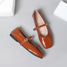 Mescini brown patent square toe mary jane flats, pair with one shoe turned on its side, US women's sizes