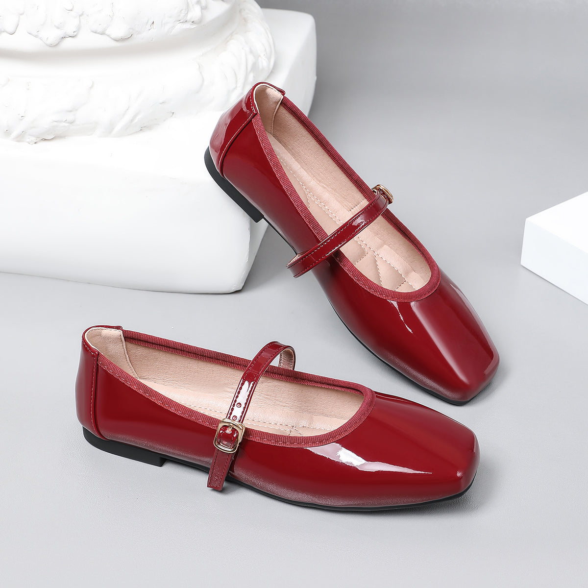 Mescini wine red patent square toe mary jane flats, pair propped on a white block, US women's sizes