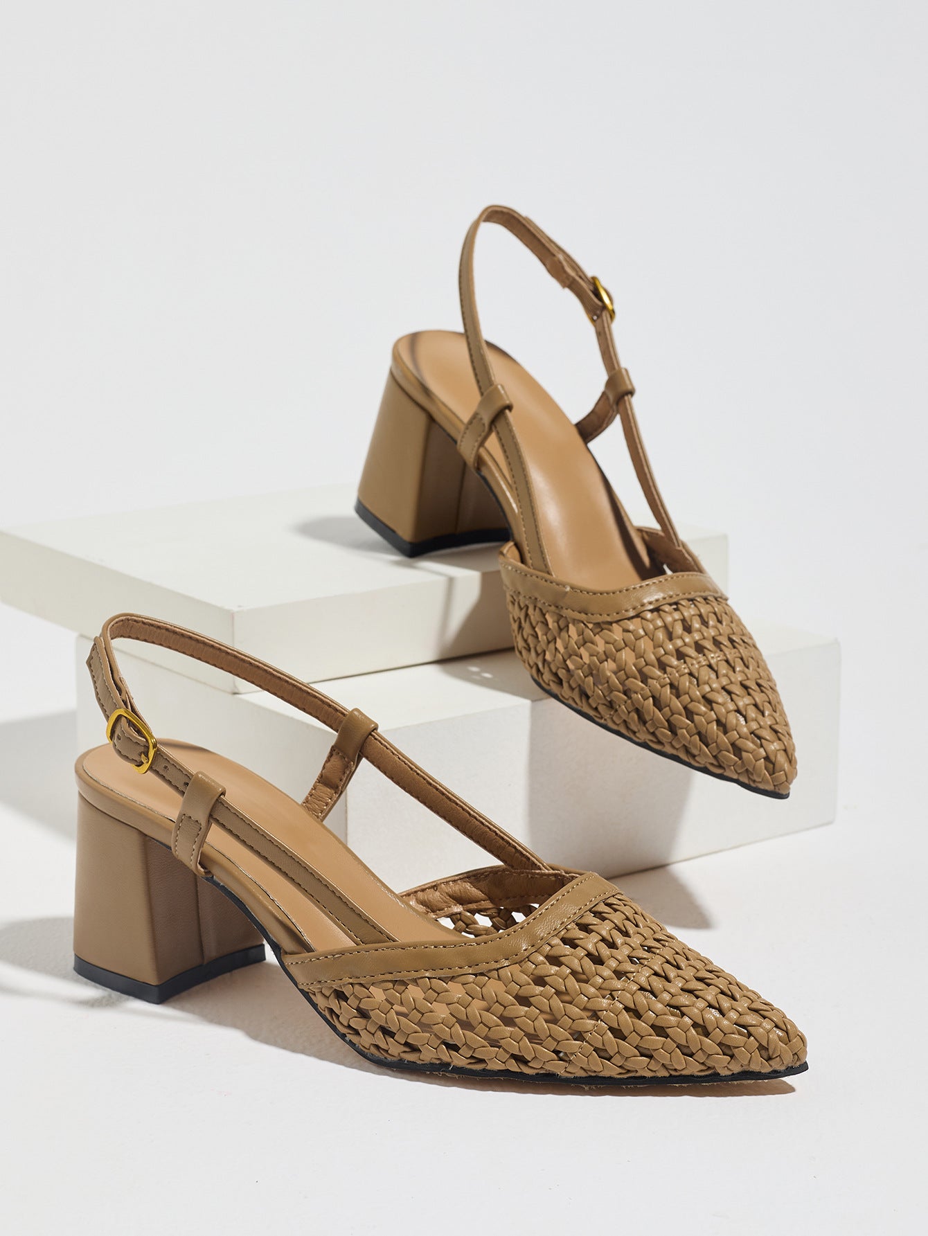 Mescini brown woven pointed toe block heel pumps, pair on white display risers, US women's sizes