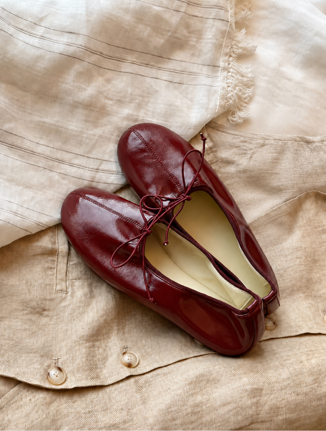Mescini burgundy soft drawstring bow ballet flats, pair laid on linen, seen from above, US women's sizes
