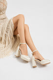 Mescini apricot satin platform Mary Jane heels, worn by a seated model in a fringed dress, US women's sizes