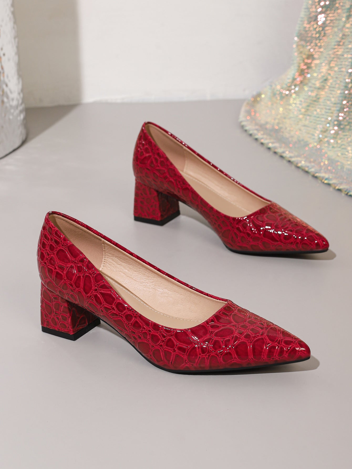 Mescini wine red croc embossed block heel pumps, the pair set on a pale step, US women's sizes