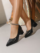 Mescini black croc embossed block heel pumps, worn by a model with legs crossed, US women's sizes