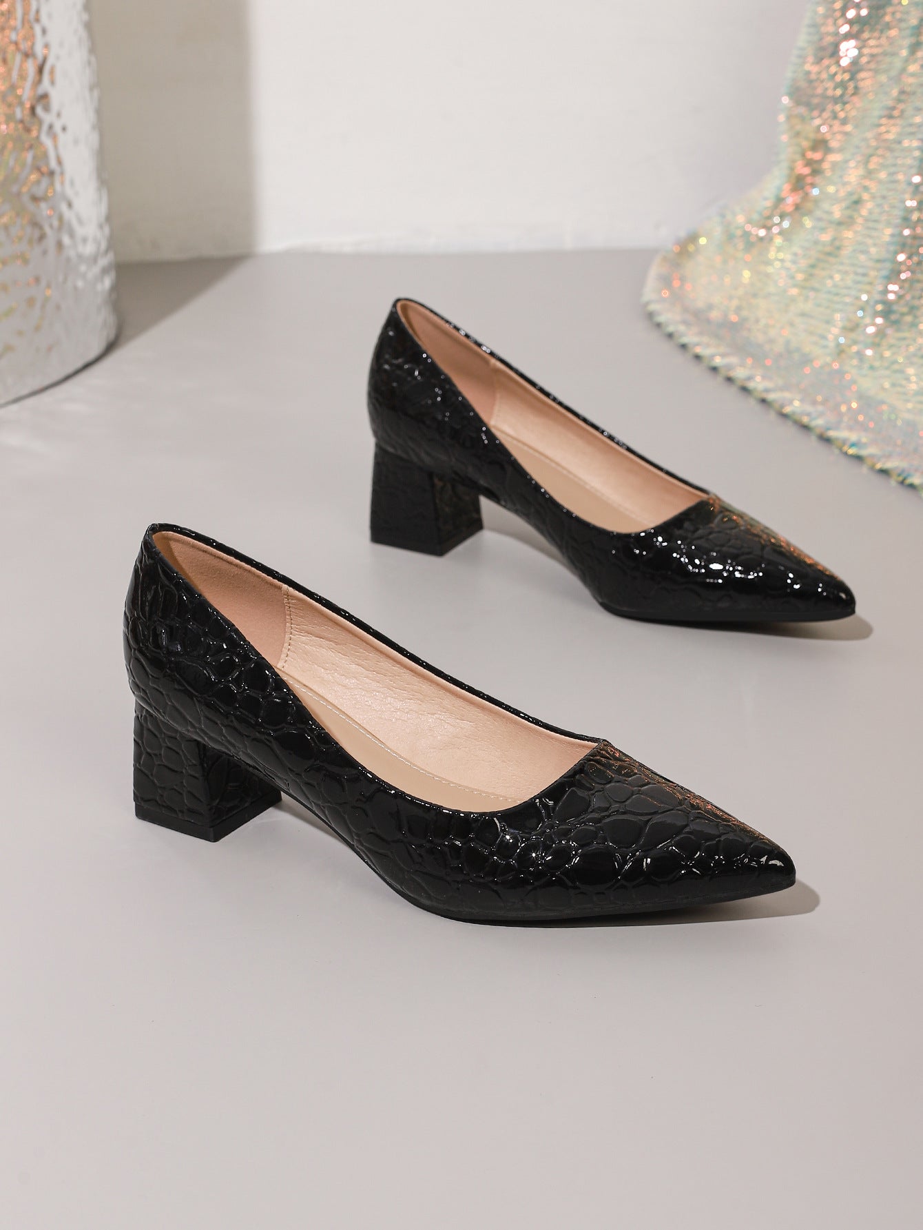 Mescini black croc embossed block heel pumps, the pair set on a pale step, US women's sizes