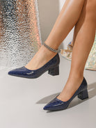 Mescini navy blue croc embossed block heel pumps, worn by a model walking past silk, US women's sizes