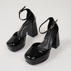 Mescini black patent platform ankle strap heels, the pair angled on a white studio floor, US women's sizes