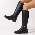 Mescini black quilted knee high boots worn with one leg lifted, US women's sizes