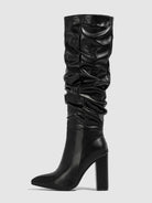 Mescini black slouchy knee high block heel boots, one boot standing on grey ground, US women's sizes