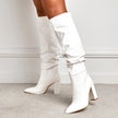 Mescini - white slouchy knee high boots on model, front view against a pale plaster wall