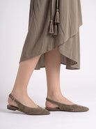 Mescini brown pointed toe slingback ballet flats, worn under a long olive dress, US women's sizes
