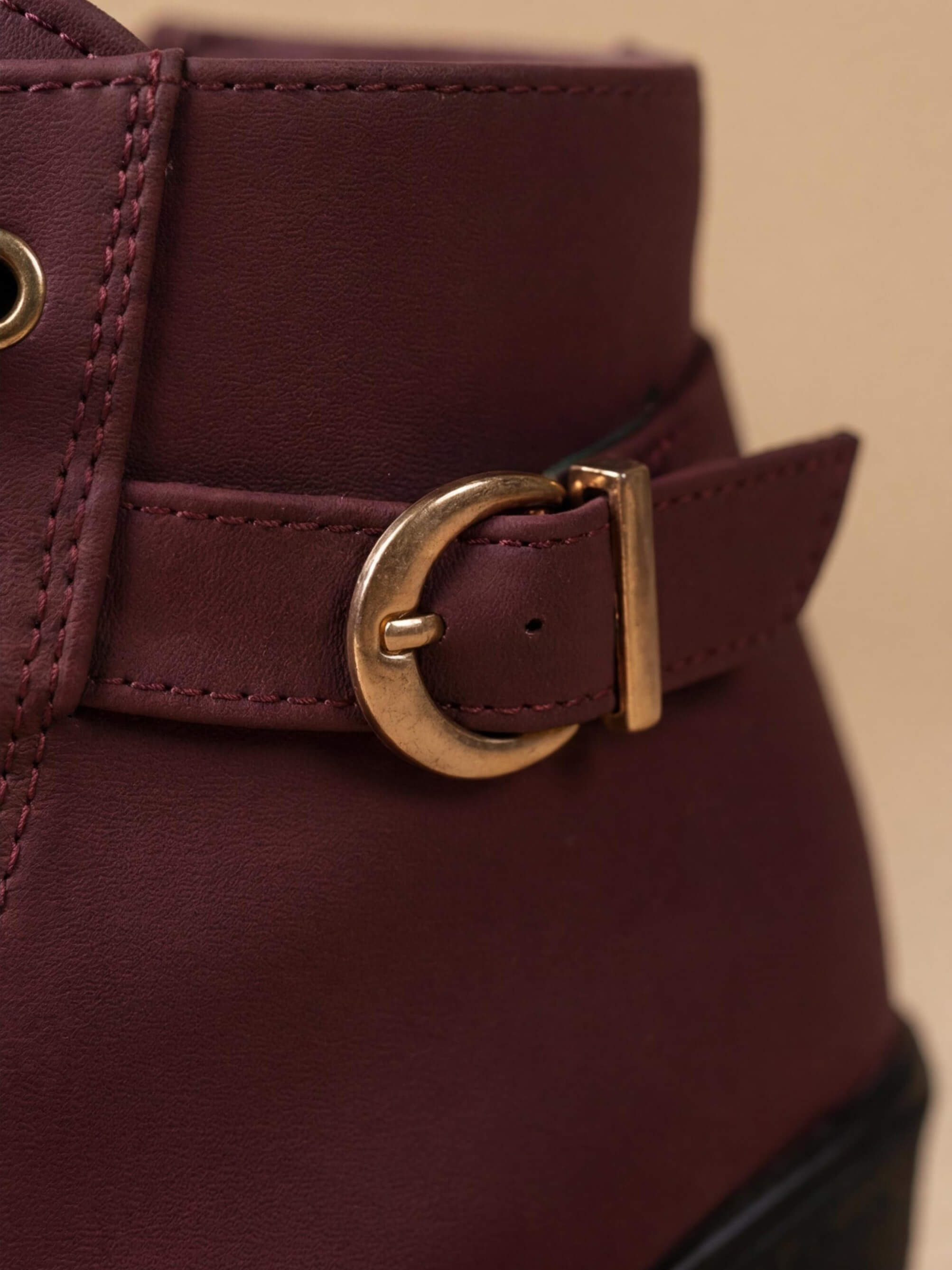 Close crop of the antique gold buckle strap on Mescini burgundy lace up ankle boots