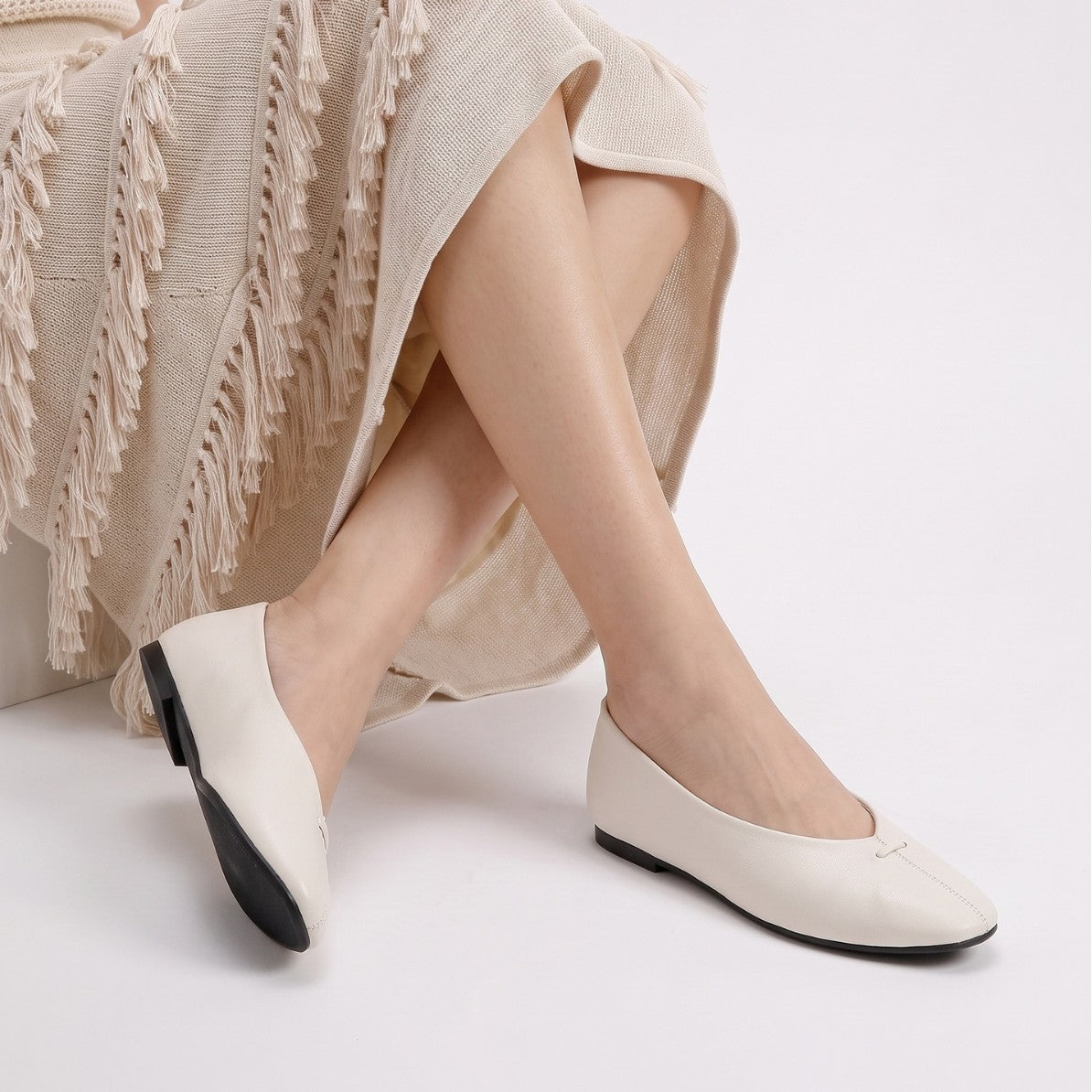 Mescini - off-white ballet flats worn seated, deep V vamp shown, US women's sizes