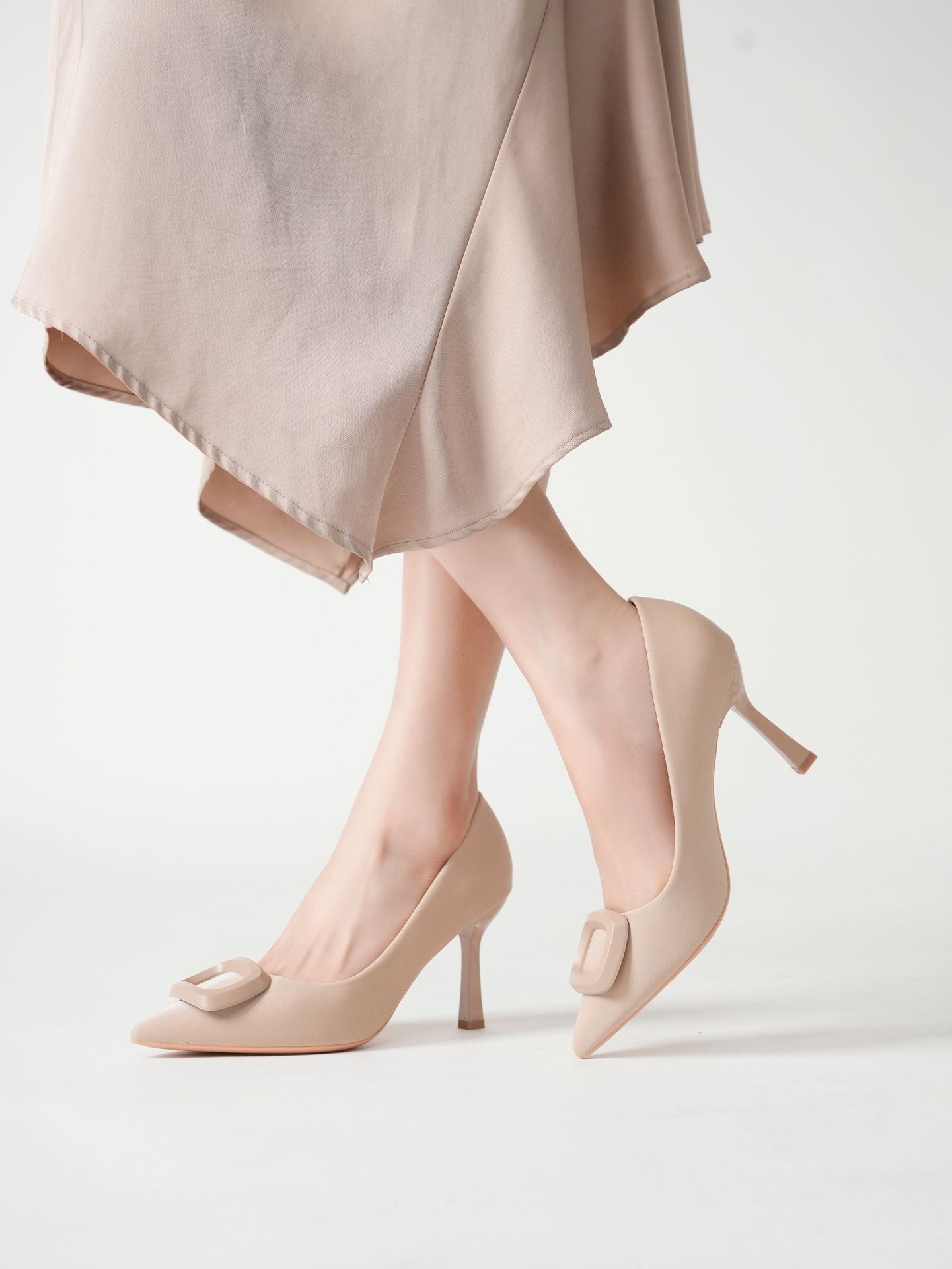 Mescini beige square ring pointed toe pumps worn with the legs crossed, US women's sizes