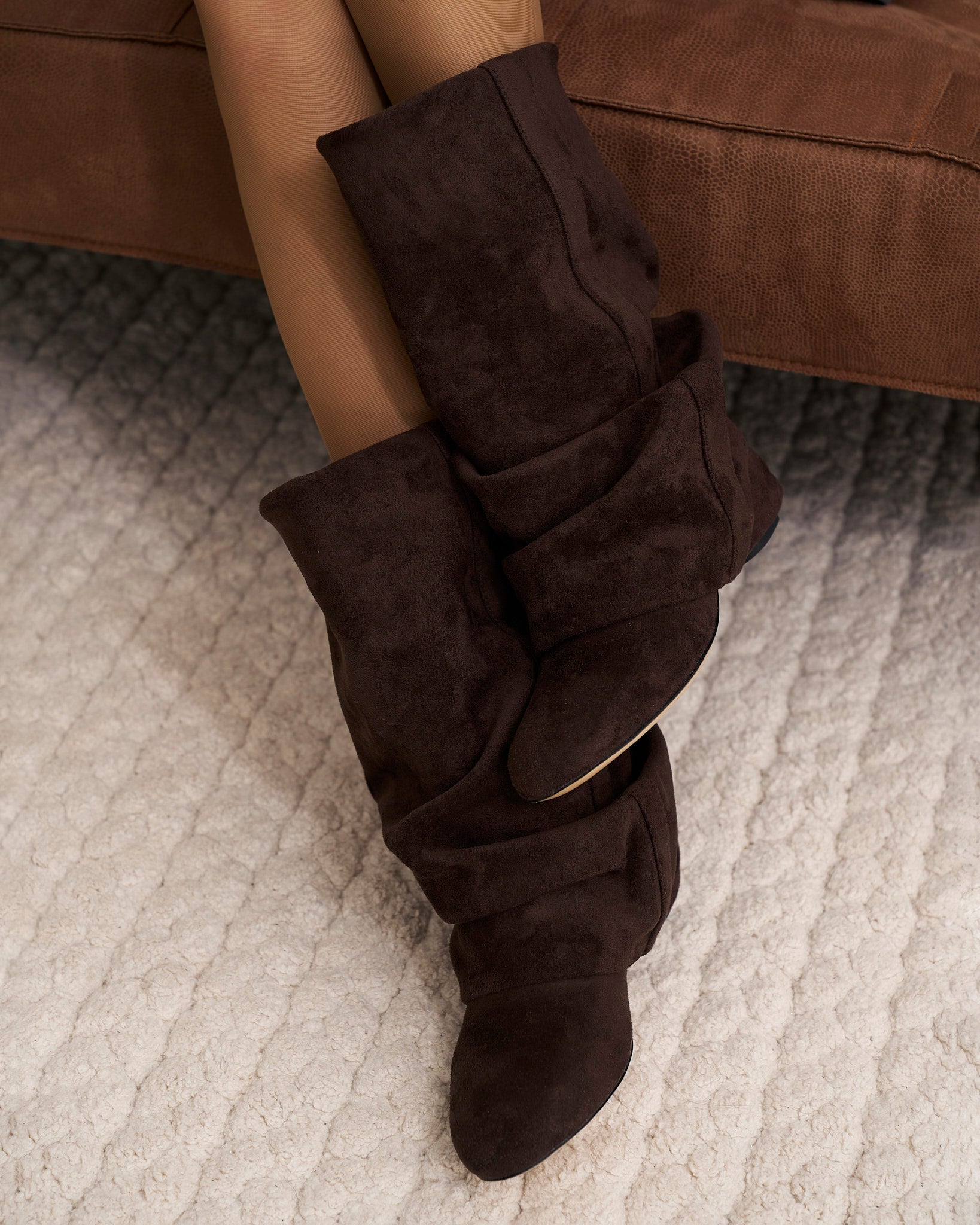 Mescini dark chocolate slouchy mid calf boots, worn by a model seated on a bench, US sizes