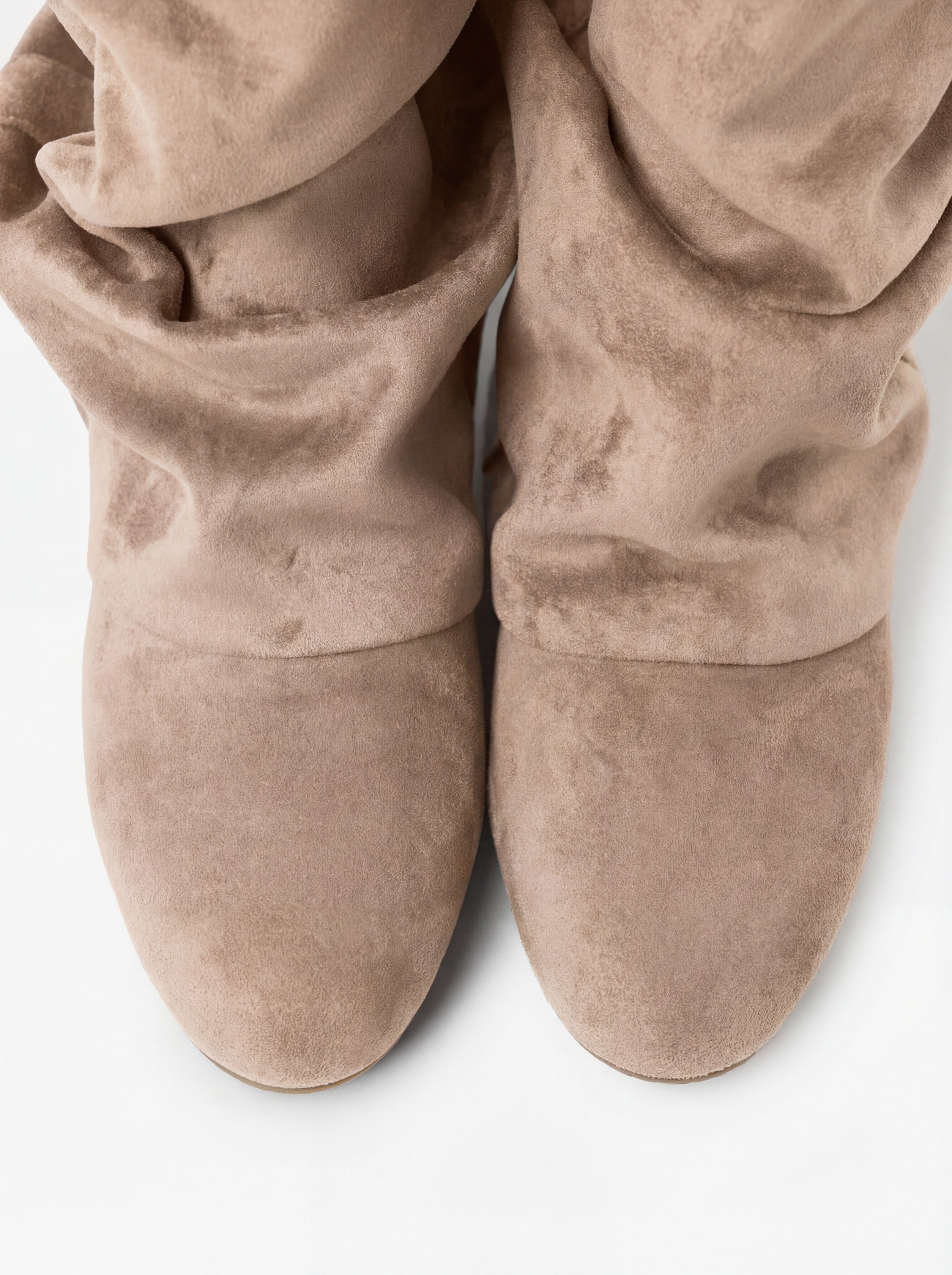 Mescini beige slouchy mid calf boots, worn on the leg beside a pale rug, US sizes