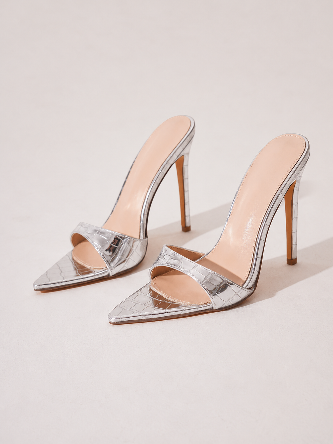 Mescini silver croc embossed pointed stiletto mules, pair placed together in the studio, US women's sizes