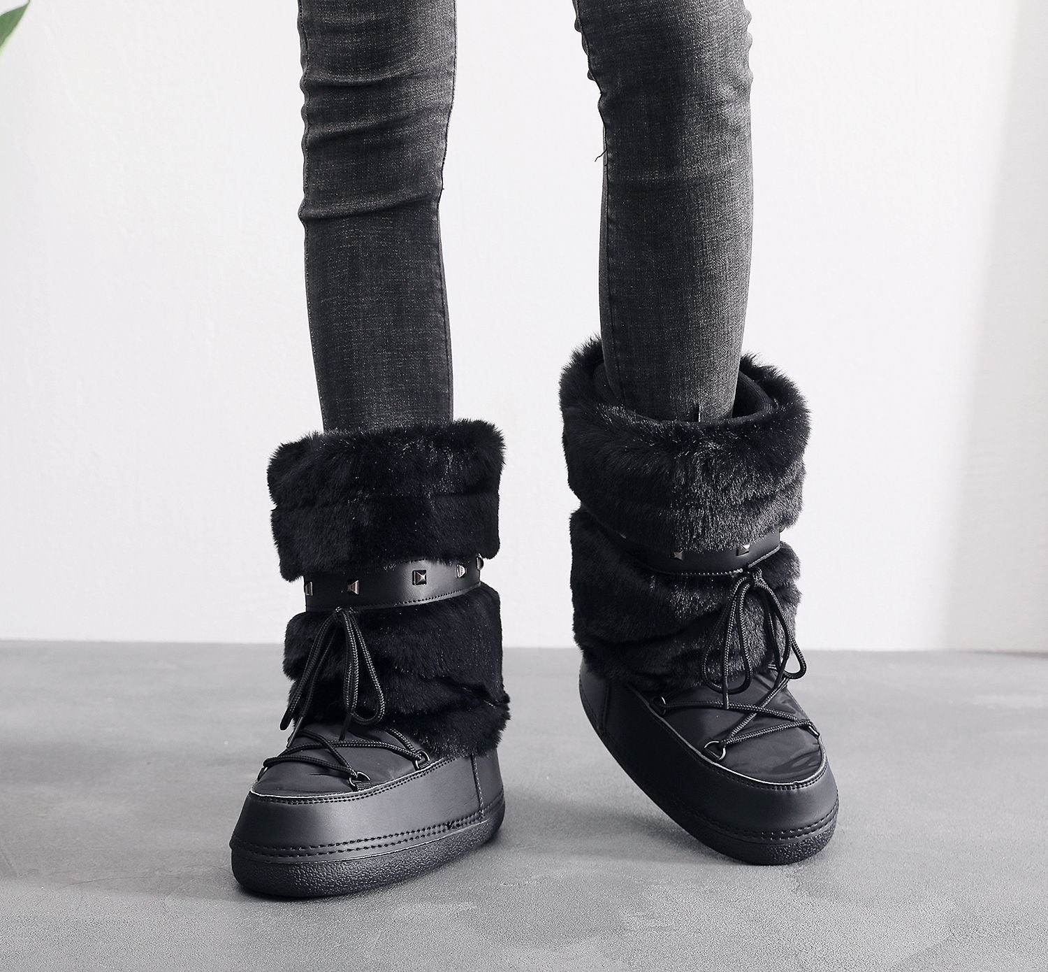 Mescini black faux fur studded platform snow boots, worn standing with grey jeans, US women's sizes