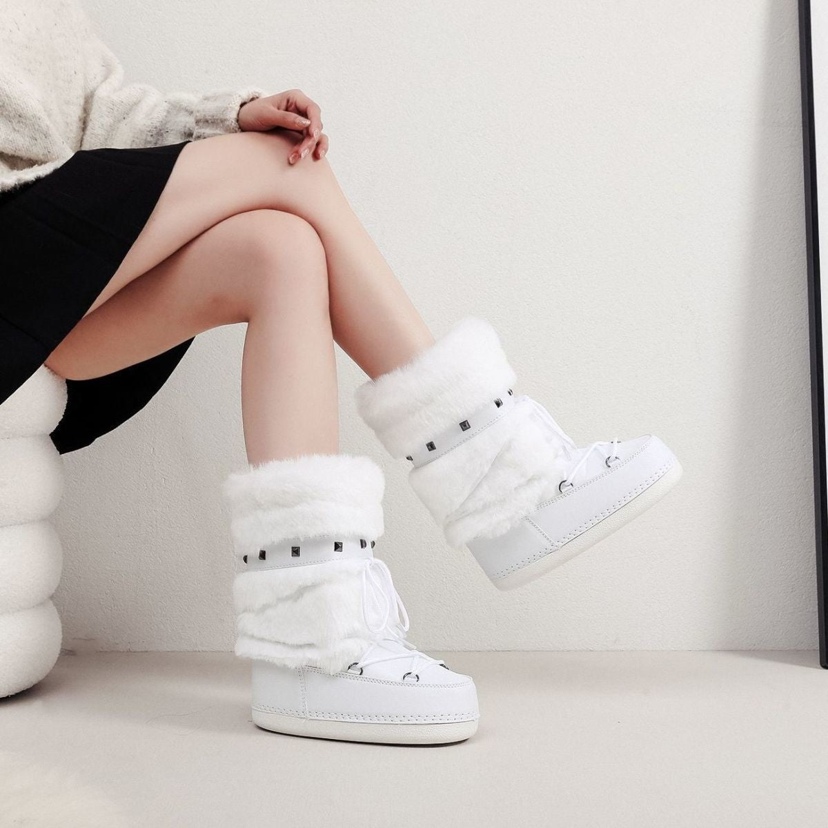 Mescini - white faux fur snow boots worn with a black skirt, seated shot, US women's sizes