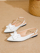 Mescini white bow pointed toe slingback flats, pair set on a woven beige surface, US women's sizes