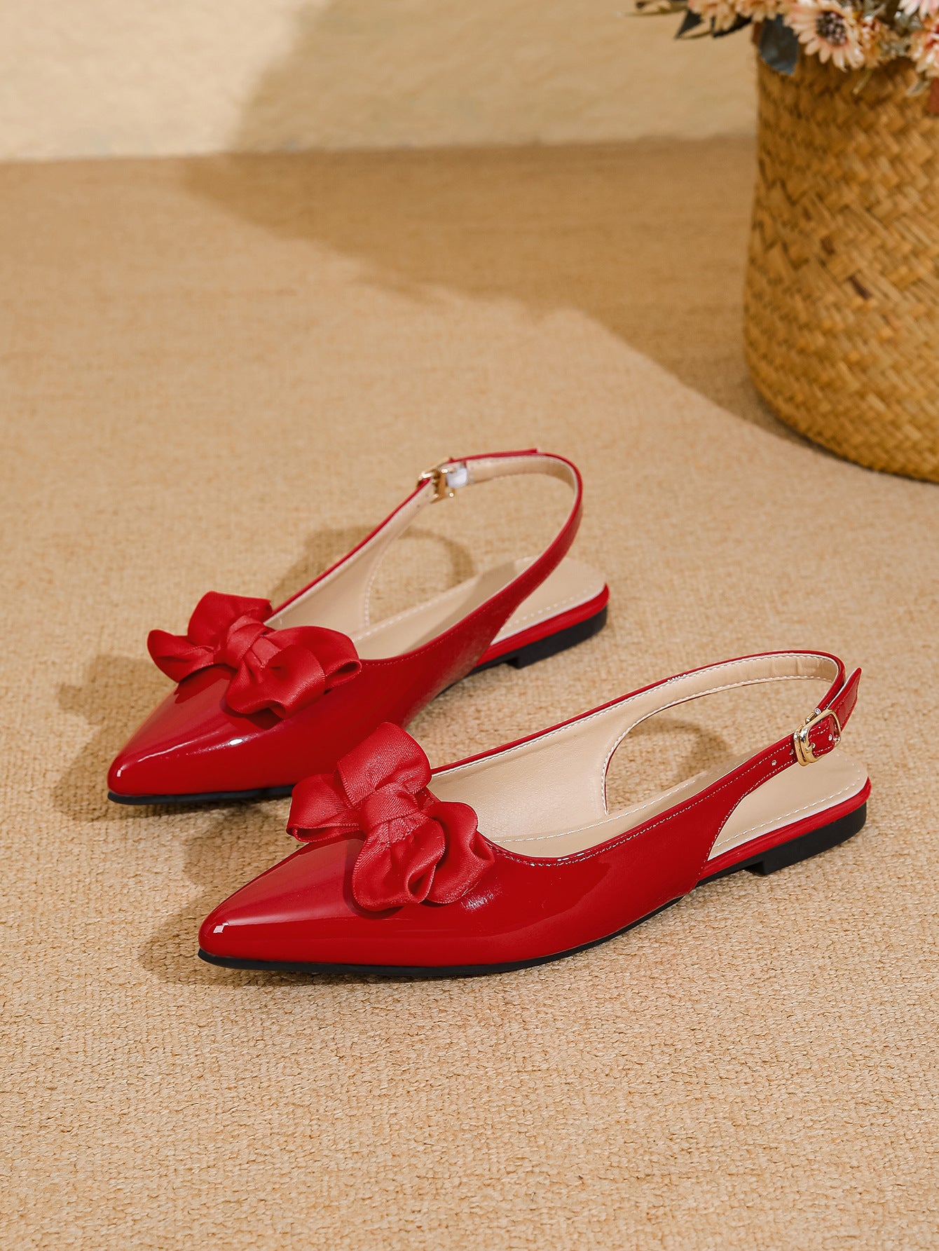 Mescini red bow pointed toe slingback flats, pair placed on a sandy coloured floor, US women's sizes