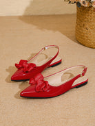 Mescini red bow pointed toe slingback flats, pair placed on a sandy coloured floor, US women's sizes