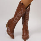Mescini brown western boots worn crossed, contrast embroidery running over both vamps