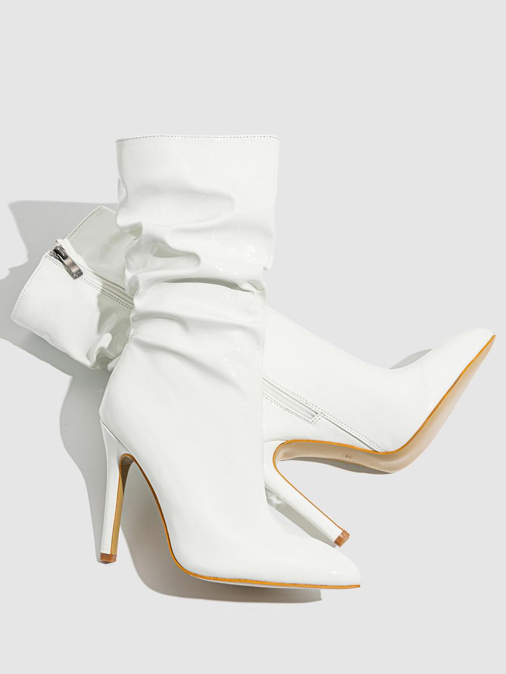 Mescini white slouchy patent mid calf boots, the pair laid on a grey studio surface, US women's sizes