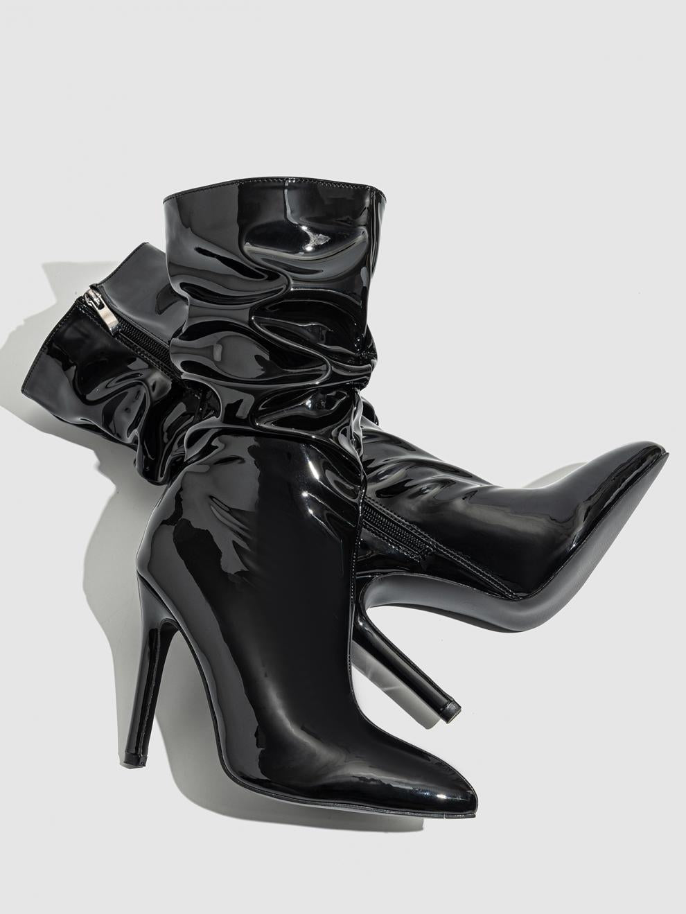 Mescini black slouchy patent mid calf boots, the pair lying down on a grey backdrop, US women's sizes