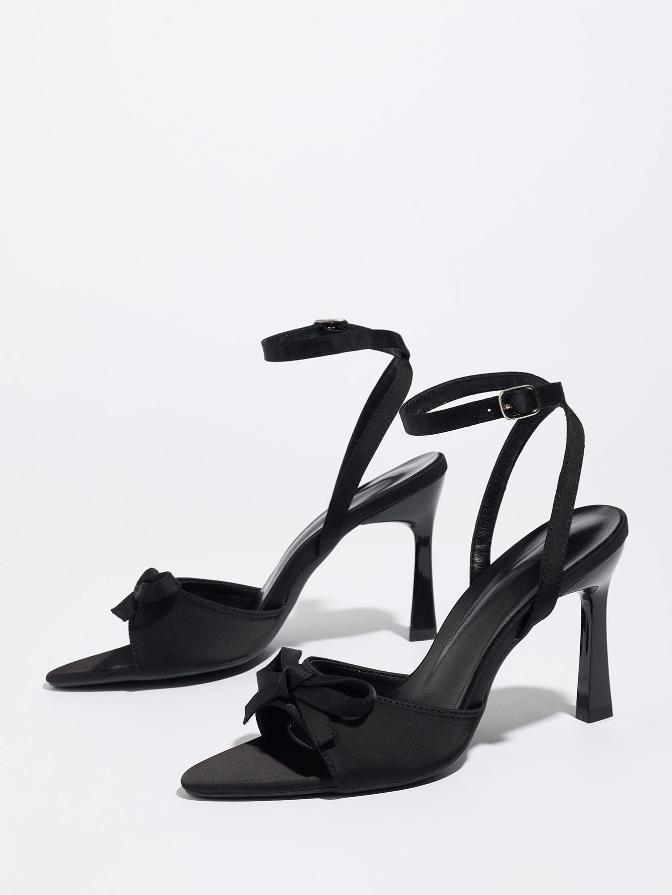 Mescini black satin bow ankle strap sandals, angled pair standing on a white surface, US women's sizes