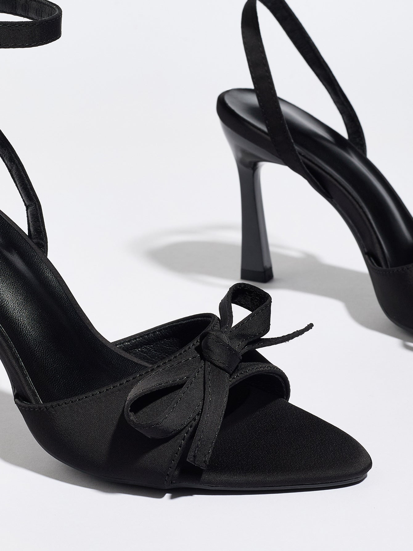 Mescini black satin bow ankle strap sandals, close up of the knotted trim and toe, US women's sizes