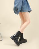 Mescini black glossy platform chelsea rain boots, worn mid stride with denim, US women's sizes